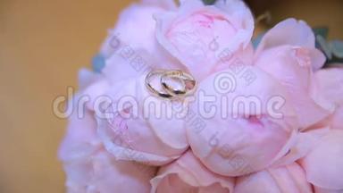 婚礼戒指在一束白色的花上。 <strong>结婚戒</strong>指和深蓝色的花束。 快关门。 婚礼